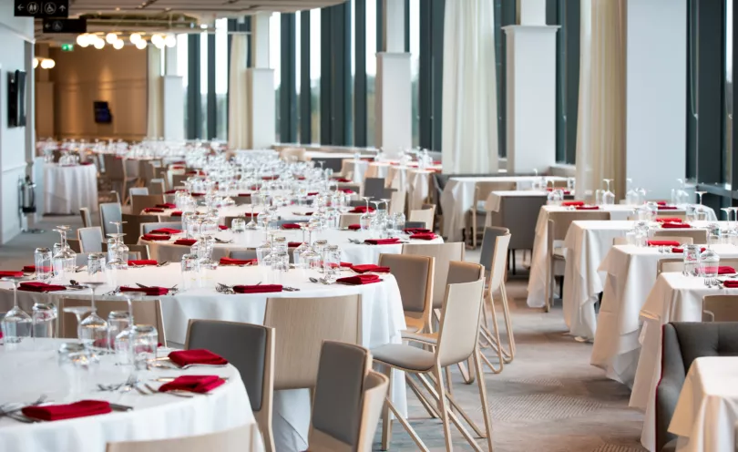 Poppy Red napkins in a stadium setting with Arctic White table cloths used as a base